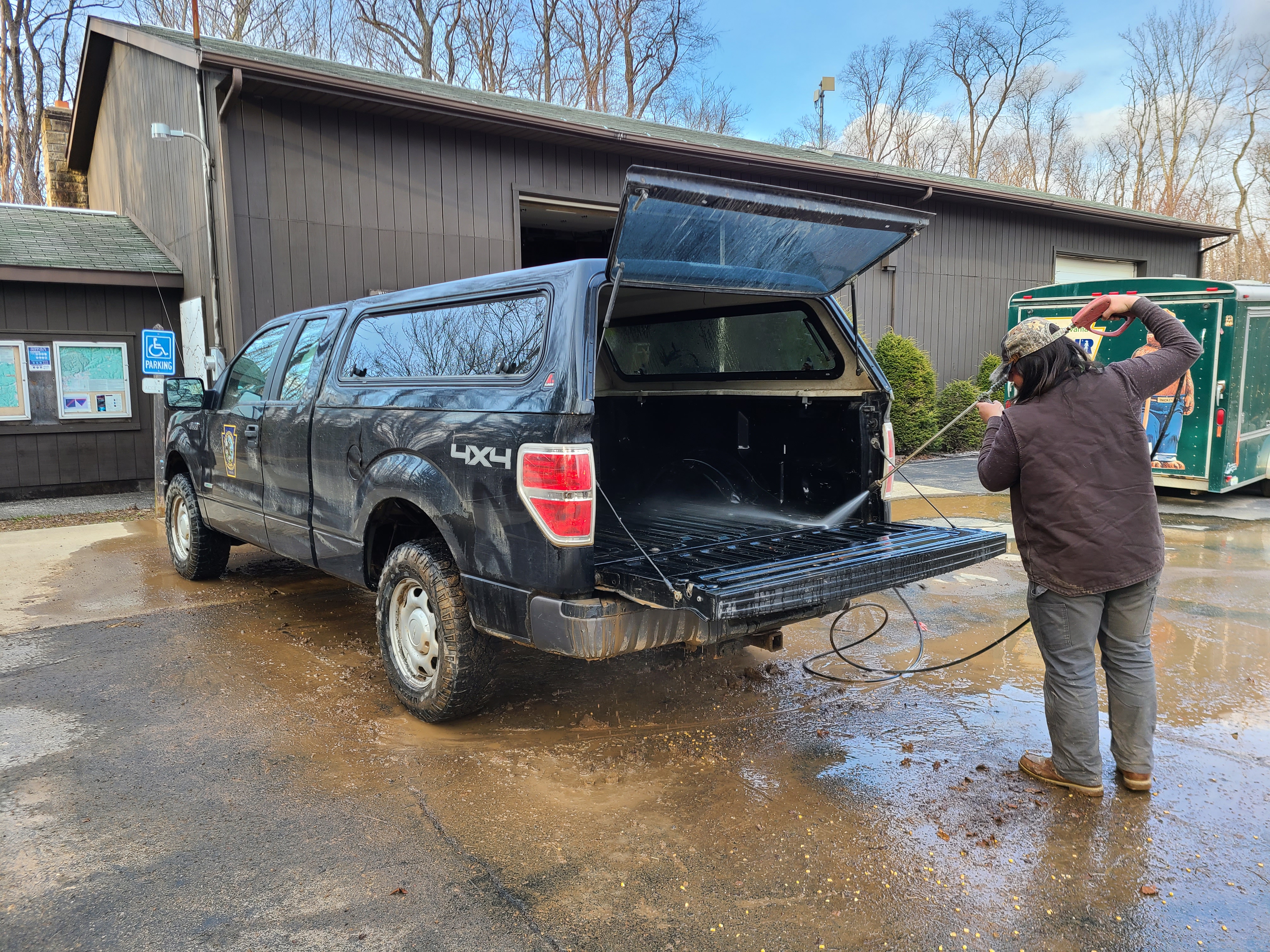 person powerwashing the bed of a truck