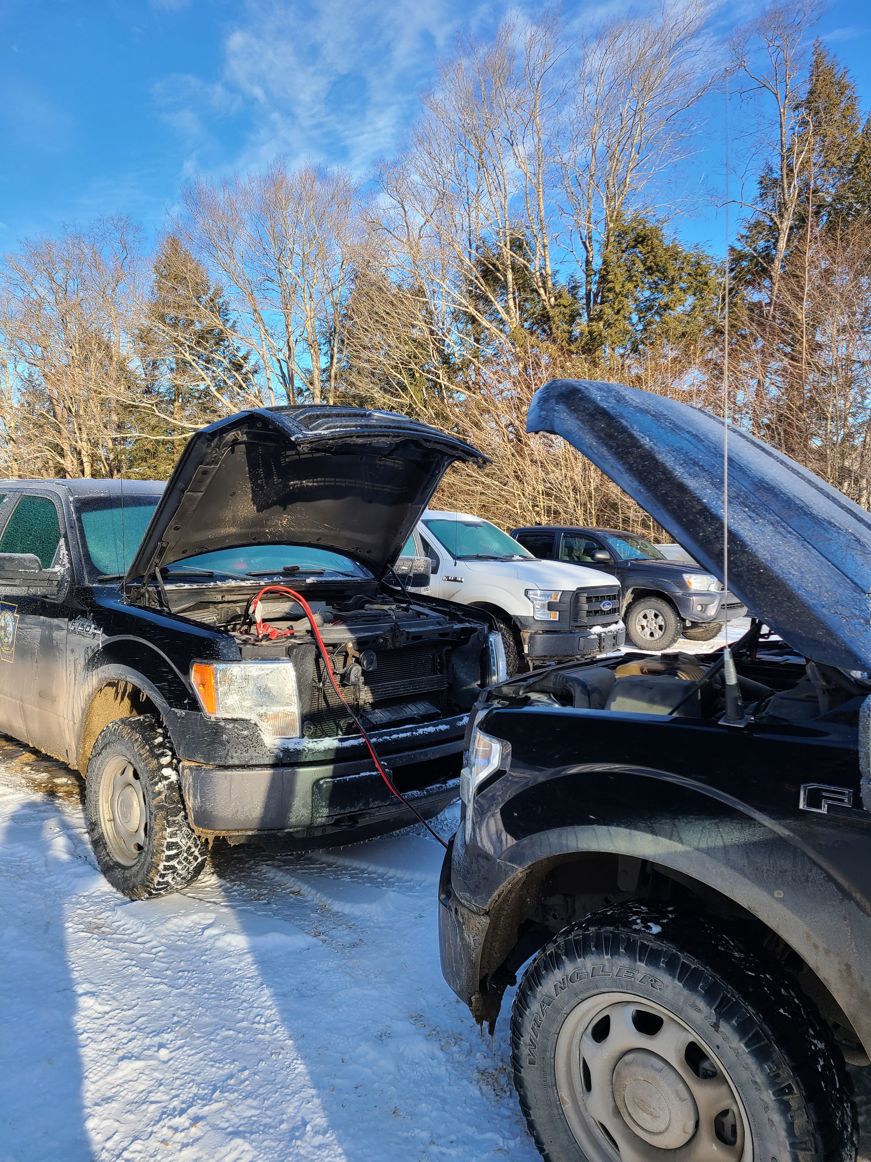 Trucks facing each other with jumper cables attached