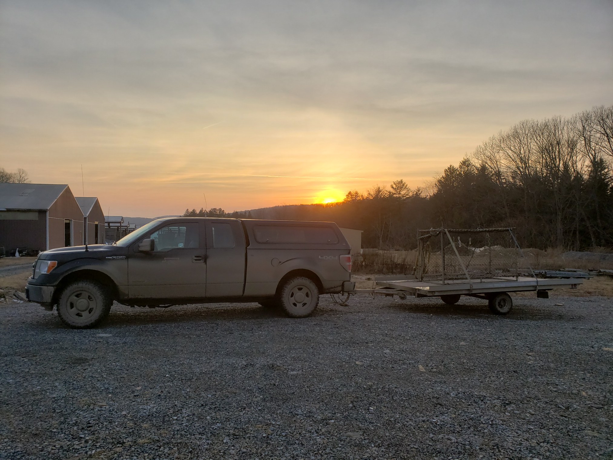 mud covered truck pulling a flat trailer