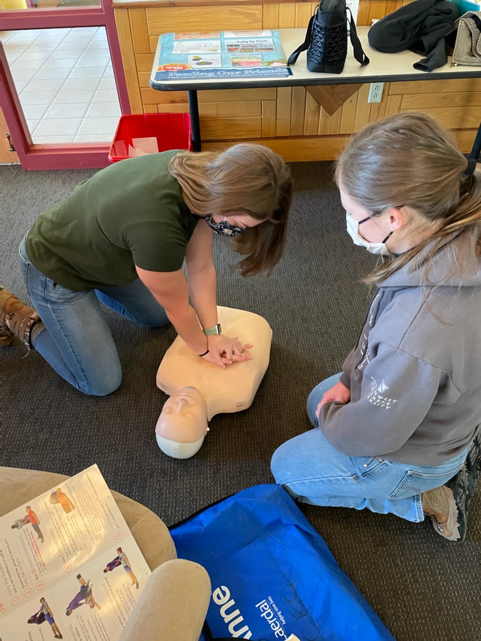 practicing chest compressions on a dummy for CPR training