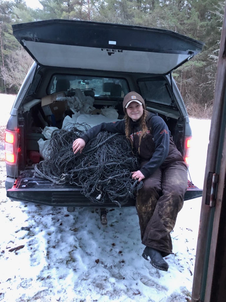 Crew member sitting of the tailgate leaning on a rocket net