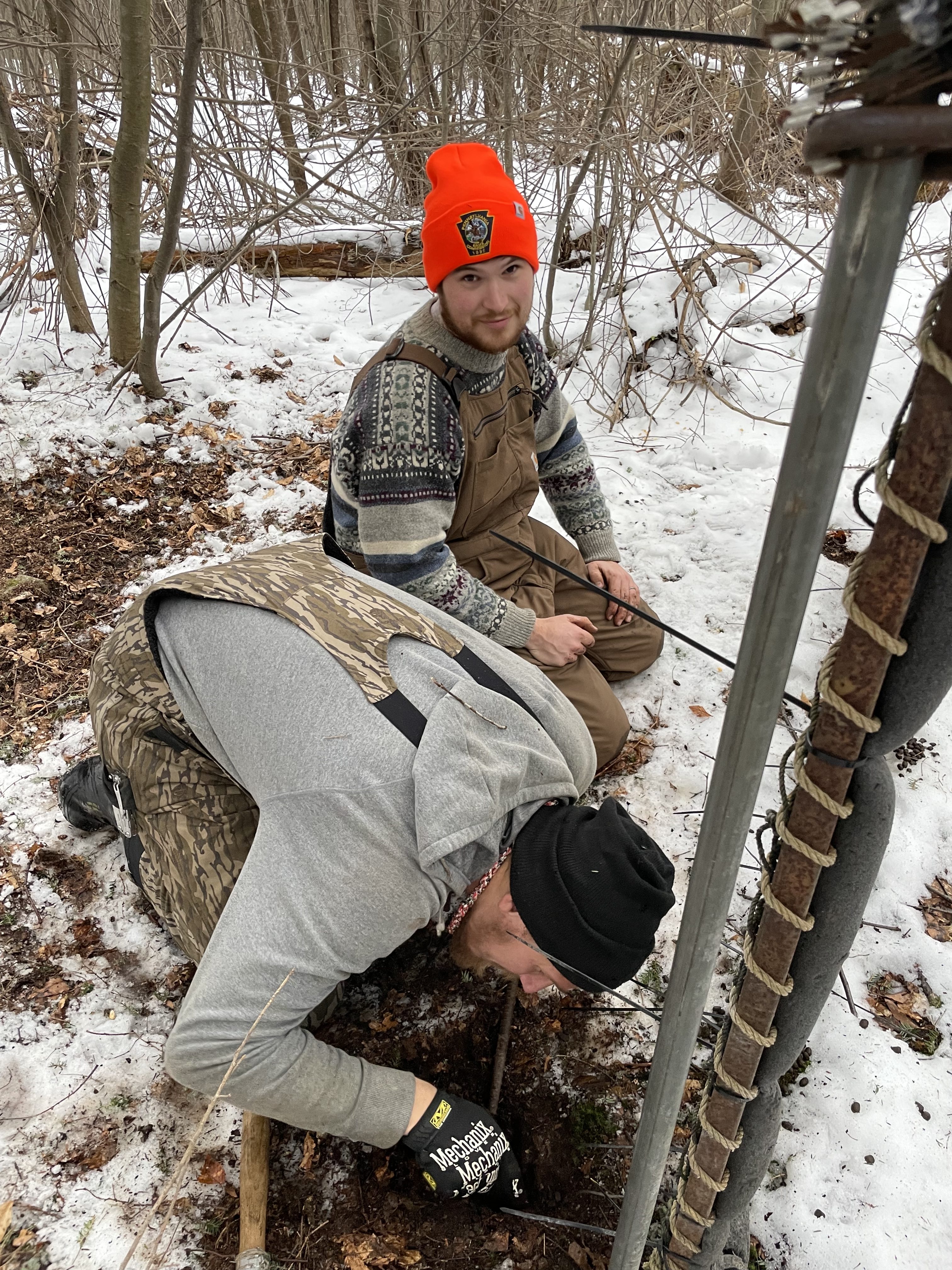 crew members securing Clover trap with rebar one is looking at the camera questioningly 