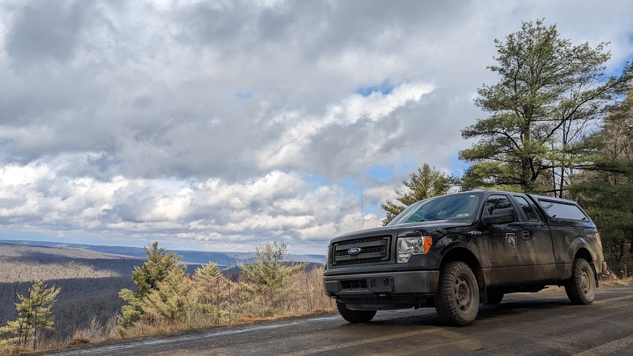 PGC Truck on a ridge raod with expanise sky and close in background