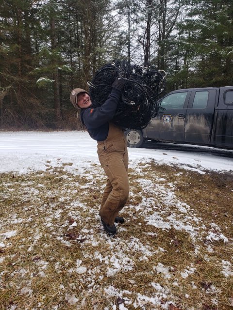 Crew member carrying a rocket net in the field